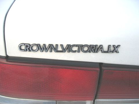 1997 Ford Crown Victoria - Close-up of the 'Crown Victoria LX' badging on the rear of a white vehicle.