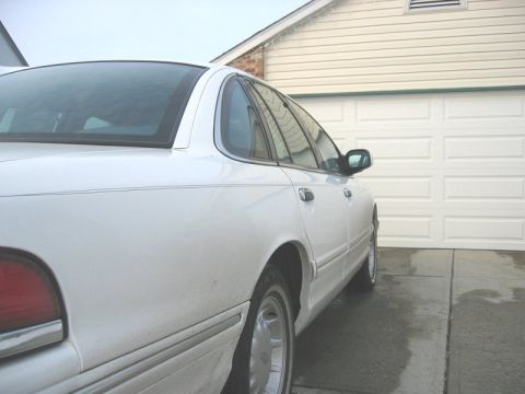 1997 Ford Crown Victoria - Rear quarter view of a white 1997 Ford Crown Victoria parked in front of a garage.