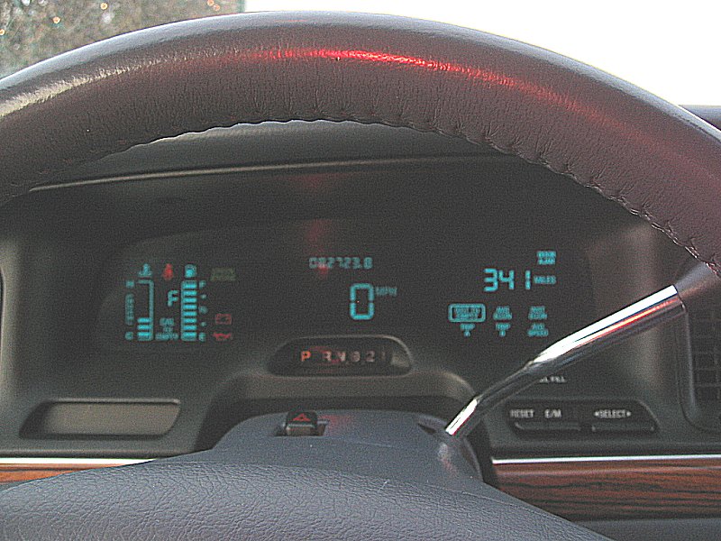 Dashboard of a 1997 Ford Crown Victoria showing digital gauges, odometer reading 082123.8, and gear selector