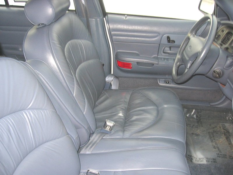 Gray leather interior of a 1997 Ford Crown Victoria, showing front seats and dashboard