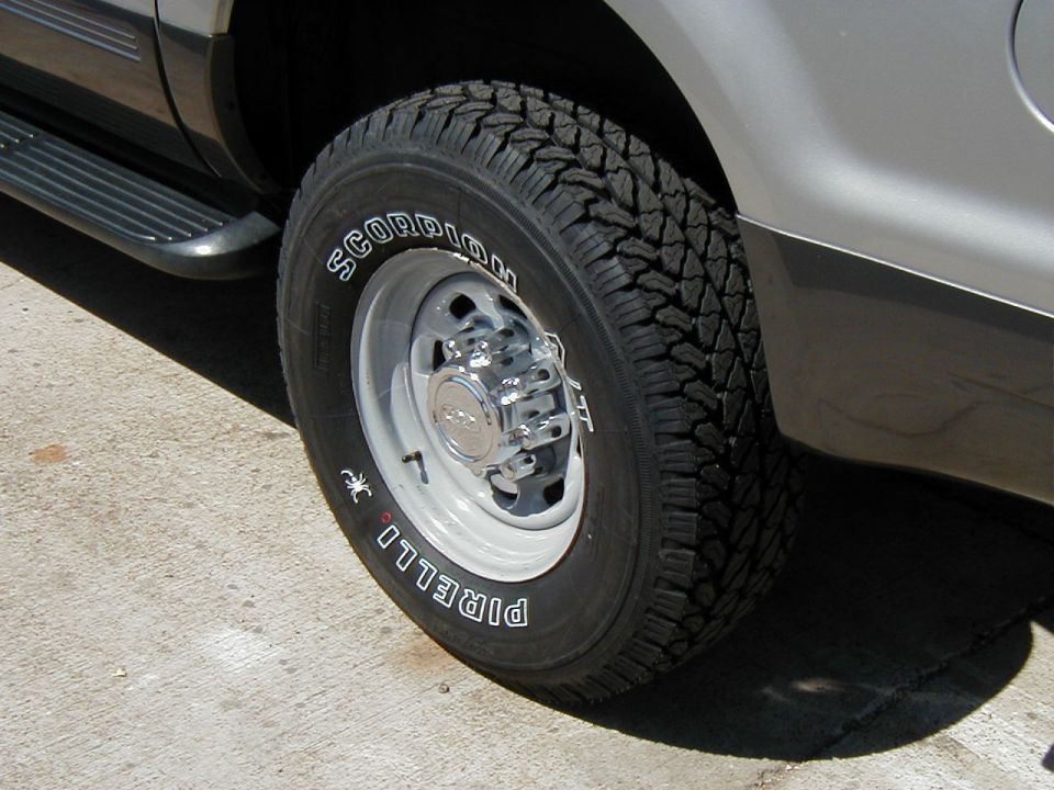 Pirelli Scorpion A/T white-letter tire on gray steel wheel of a silver SUV