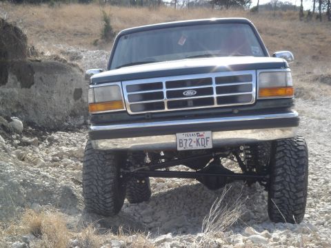 1995 Ford Bronco - This 1995 Ford Bronco is shown from the front, lifted for off-roading on a rocky path.