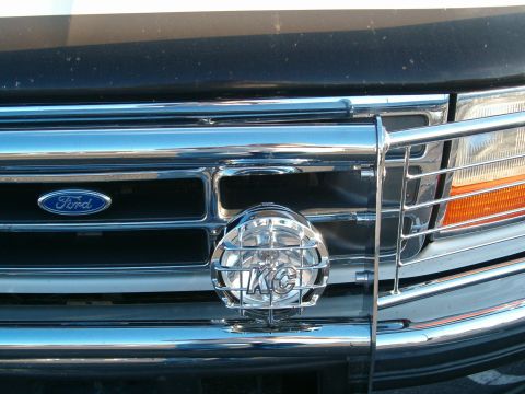 1996 Ford Bronco - The Ford emblem and grille design are consistent with a 1996 Bronco, complemented by a KC light and chrome grille guard.