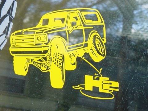 1989 Ford Bronco - A yellow sticker depicts a lifted truck with "H2" branding, applied to a dusty window.