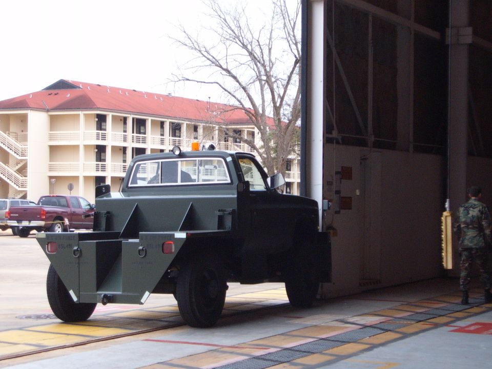 Green flatbed truck with custom bed, 3q front view