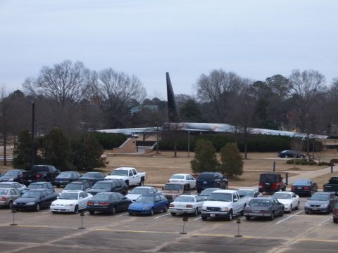 1988 Ford Bronco - A wide view of a parking lot filled with numerous vehicles, with a large airplane visible in the distance.