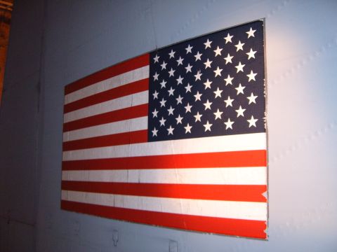 1988 Ford Bronco - An American flag is displayed on a textured gray wall, with a watermark at the bottom right.