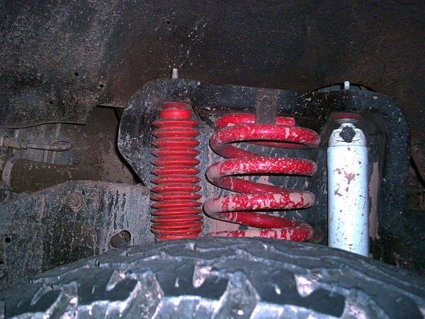 Red coil spring and shock absorber with red bellows, part of vehicle suspension