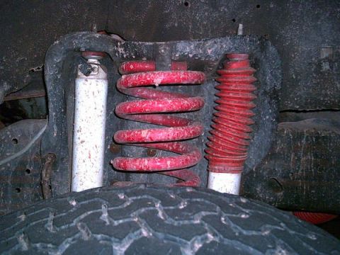 1988 Ford Bronco - Close-up of front suspension components including a coil spring and shock absorber.