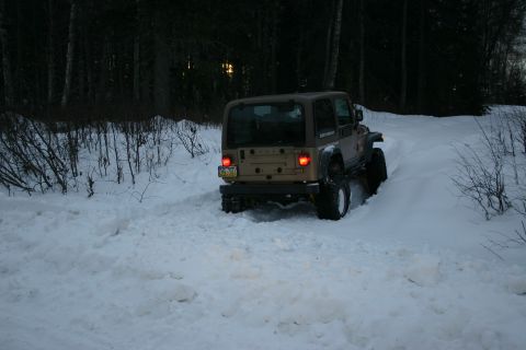 2003 Jeep TJ - 2003 Jeep TJ navigating a snow-covered path through trees.