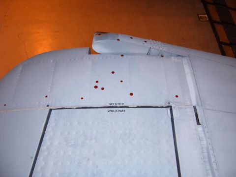 1988 Ford Bronco - A close-up view of an aircraft's exterior shows markings and red dots on its metallic surface.