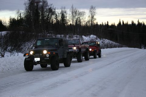 2003 Jeep TJ - A convoy of Jeeps, including a black 2003 Jeep TJ, travels down a snow-covered road.