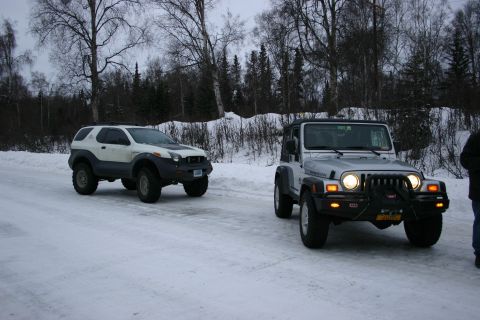 2003 Jeep TJ - A silver 2003 Jeep Wrangler is seen from the front on a snowy road, accompanied by another SUV.