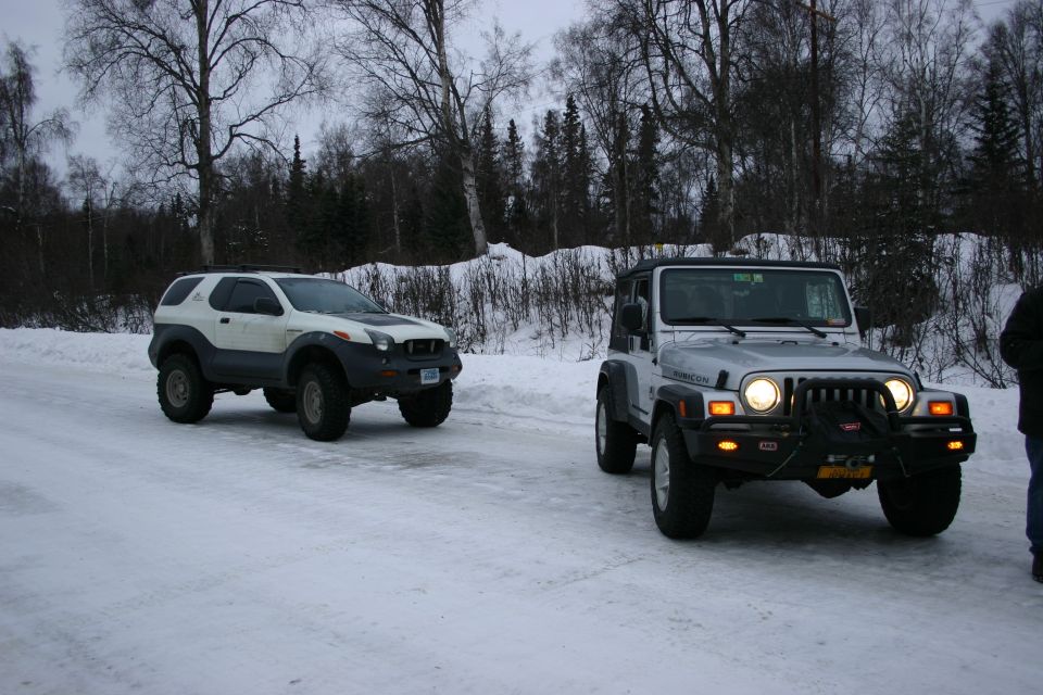 Silver 2003 Jeep Wrangler front view with winch and aftermarket bumper on a snowy road
