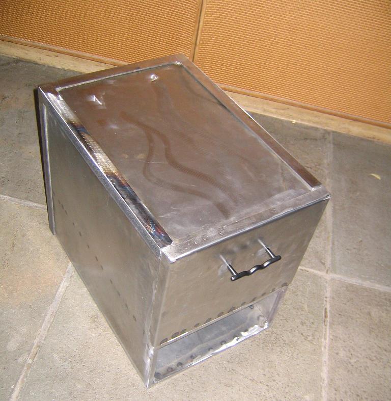 metal box with a handle on the front, sitting on a tiled floor