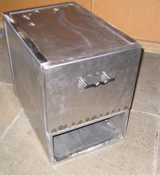 Metal mailbox with a hinged lid and a pull handle, showing rivets along the bottom edge