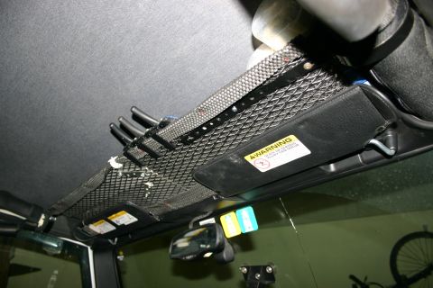 2003 Jeep TJ - A close-up view of an aftermarket overhead storage rack installed inside a vehicle's cabin.