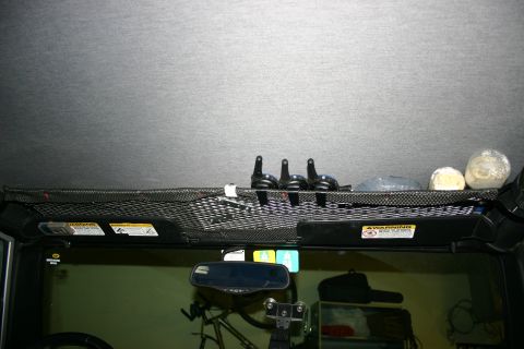 2003 Jeep TJ - Interior view of a vehicle's overhead storage net containing various items.