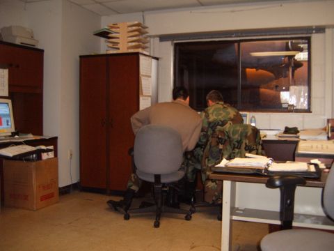 1988 Ford Bronco - Two individuals in camouflage uniforms are engrossed in their work at computers within an office setting.