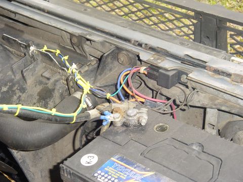 1989 Ford Bronco - Custom wiring connects to a car battery, including a relay and various colored wires.