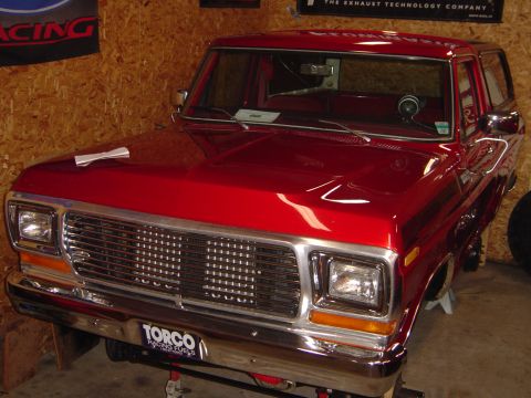 1978 Ford Bronco - A red 1978 Ford Bronco is shown from the front three-quarter view, supported by jack stands.