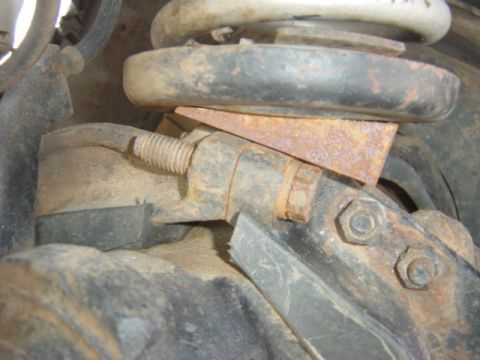 1979 Ford Bronco - Close-up of rusty suspension components, including bolts and a metal bracket.