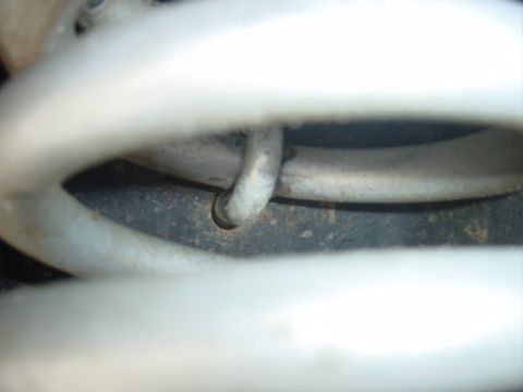 1979 Ford Bronco - Detail of a vehicle's suspension coil spring and clip, likely from the undercarriage.