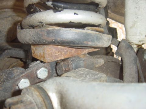 1979 Ford Bronco - This image shows a close-up view of the suspension system, including a coil spring and rusty metal components.