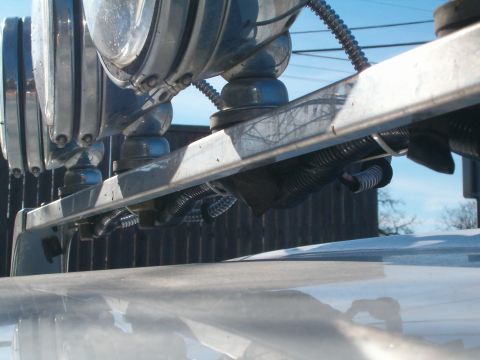 1996 Ford Bronco - Aftermarket auxiliary lights are mounted on a bar, with wiring visible underneath.