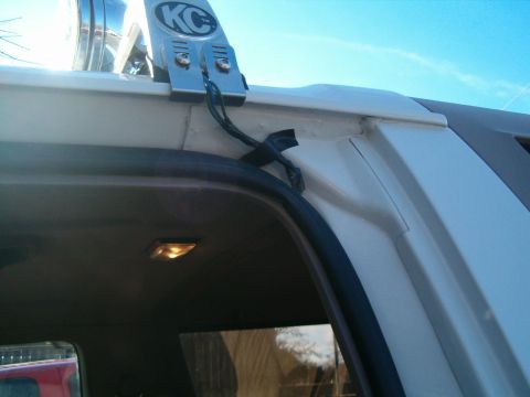 1996 Ford Bronco - Close-up of a KC light bar installation on the roof of a vehicle, showing wiring and mounting details.