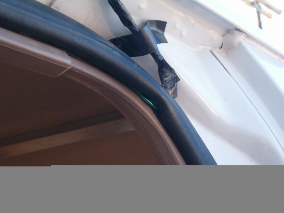 Door seal and taped wiring on white vehicle