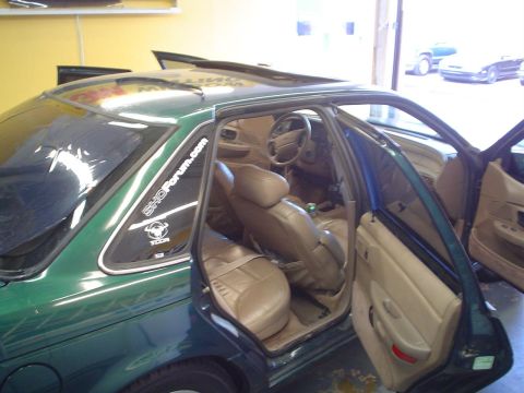 1993 Ford Taurus - Interior view of a green 1993 Ford Taurus sedan, showing tan leather seats and a sunroof.