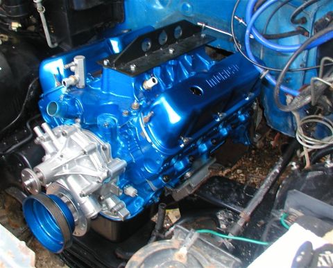 1990 Ford Bronco - A freshly painted V8 engine sits in the engine bay, a prominent water pump and blue accents.