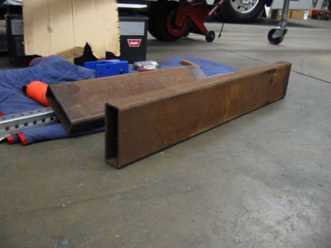 1992 Ford Bronco - Two rusty steel tubes are laid out on a blue blanket in a garage setting.