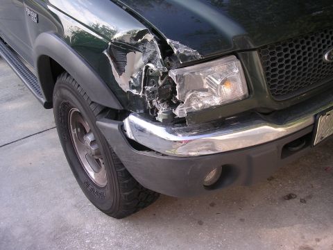 1985 Ford Bronco - The front passenger side fender and headlight assembly of a green Ford Ranger pickup truck are severely damaged.