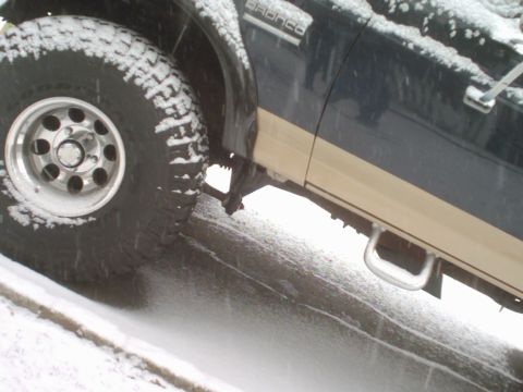 1989 Ford Bronco - A 1989 Ford Bronco is seen from the side, with snow covering its tires and body.