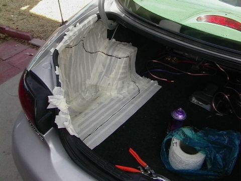 1999 Ford Taurus - A mold is being created in the trunk of a car for a custom subwoofer enclosure, with tools and supplies nearby.