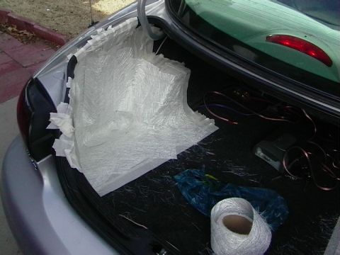 1999 Ford Taurus - The trunk of a 1999 Ford Taurus shows fiberglass matting and wiring, possibly for a sound system installation.