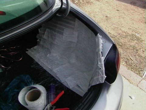 1999 Ford Taurus - The trunk of a car is shown with materials for a project, including fiberglass matting and tools.