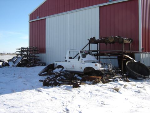 1992 Ford Bronco - White Suzuki Samurai pickup conversion in a snowy yard with a barn and scrap metal.