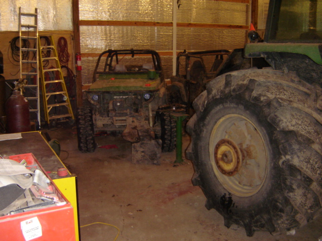 Green Suzuki Samurai with roll cage in a garage, front view