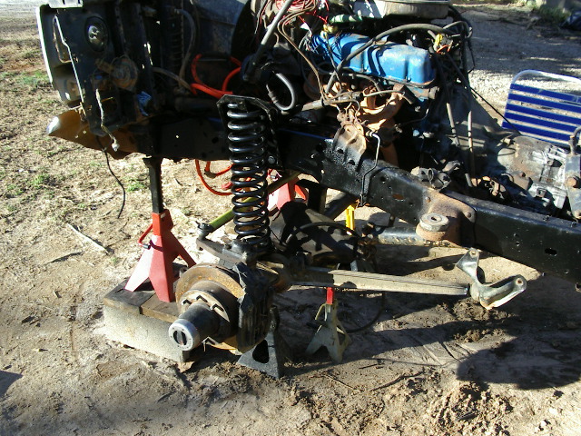 vehicle frame on jack stands, engine and front suspension exposed
