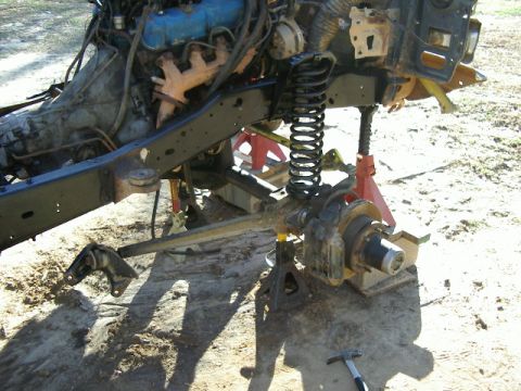 1985 Ford Bronco - The front end of a vehicle is disassembled, showing the engine and suspension components.