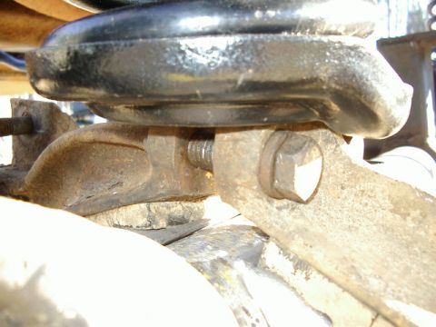 1985 Ford Bronco - Close-up of a vehicle's suspension system, showing a rusty bracket and bolt.