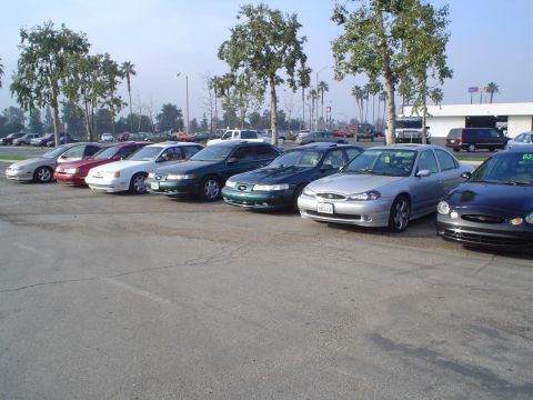 1993 Ford Taurus - A line of sedans parked in a lot, with a silver Ford sedan prominently in the foreground.
