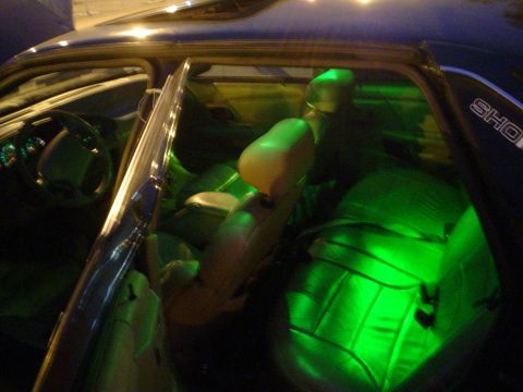 1993 Ford Taurus - Interior view of a car with custom green underglow lighting illuminating the seats.