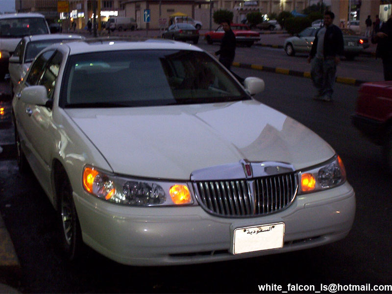 White sedan with chrome grille and amber turn signals. License plate visible