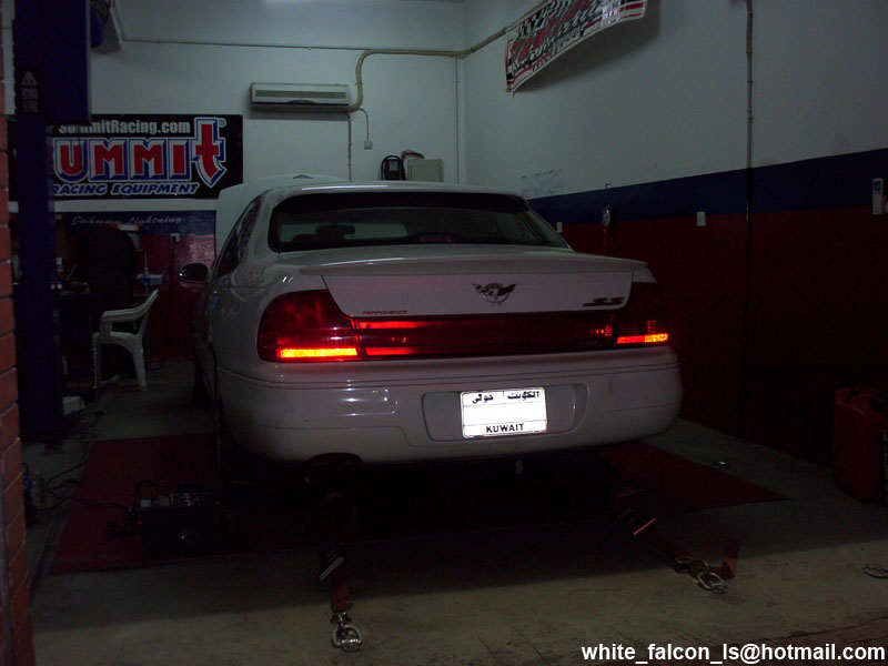 1999 Mercury Grand Marquis on a dynamometer in a garage, rear view. License plate reads KUWAIT