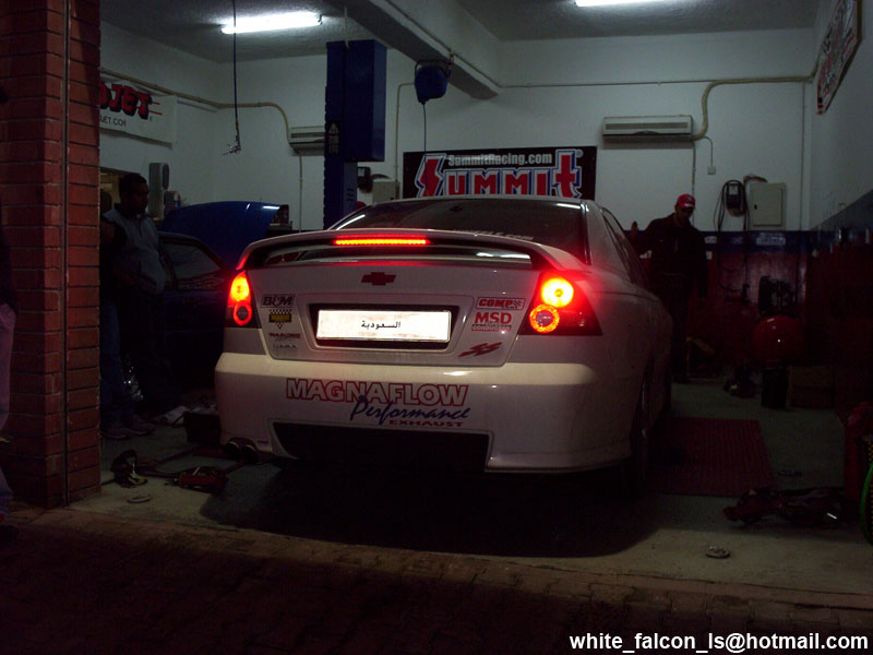 Rear view of white sedan with Magnaflow exhaust and spoiler