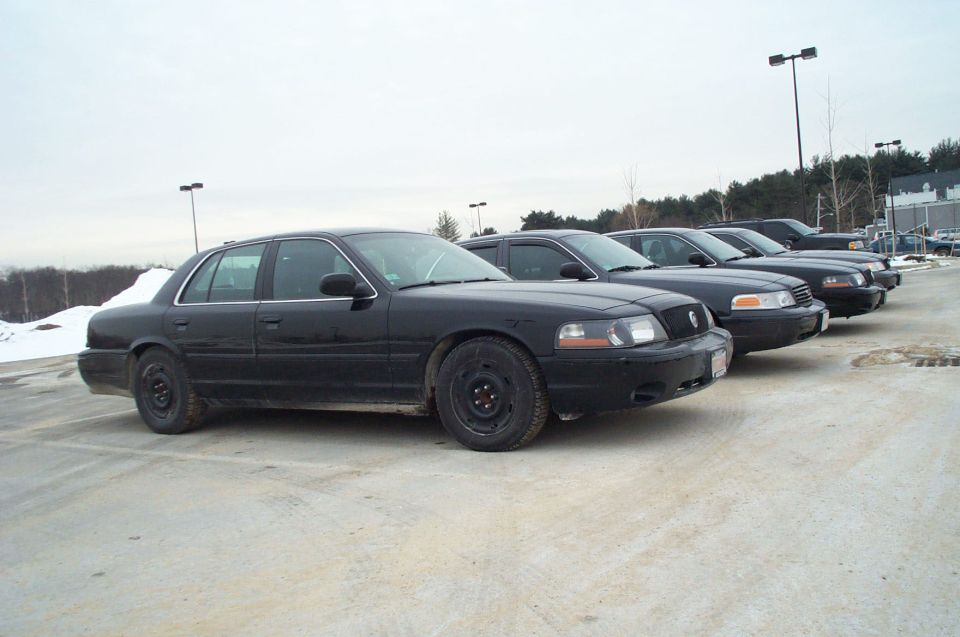 Black 2001 Ford Crown Victoria sedans parked in a lot